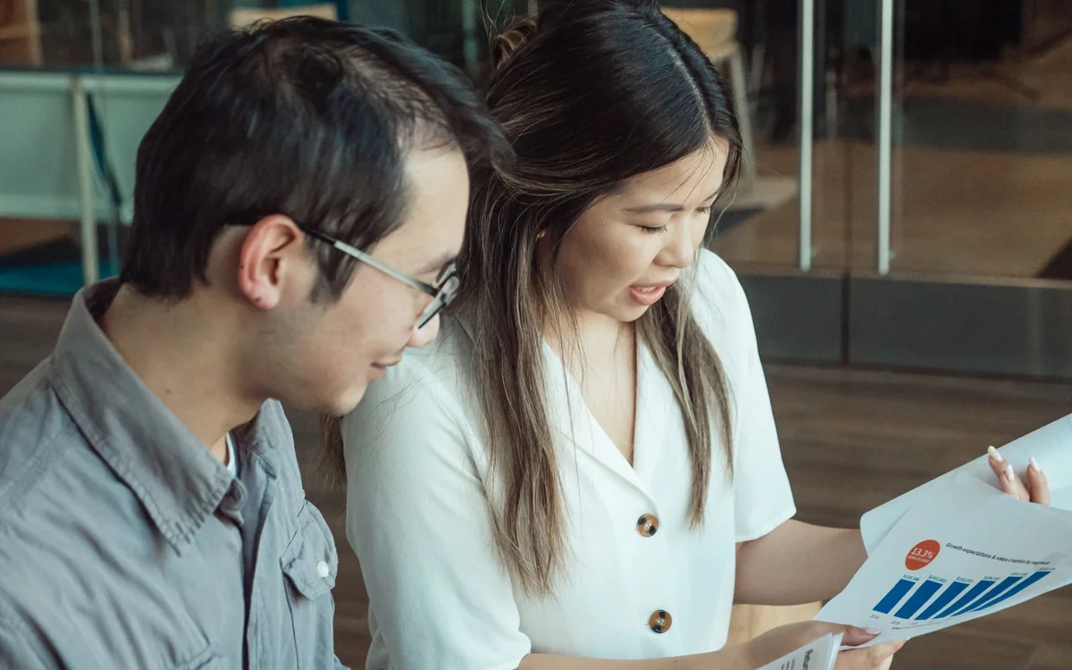 Two colleagues reviewing business charts and documents