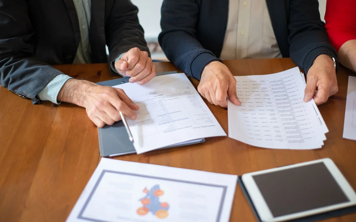 Business colleagues reviewing printed documents at a table
