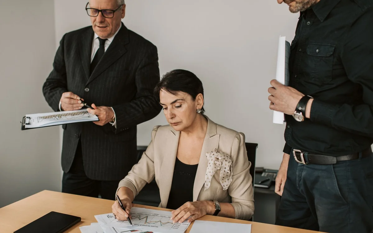 Business professionals reviewing documents and a laptop in an office