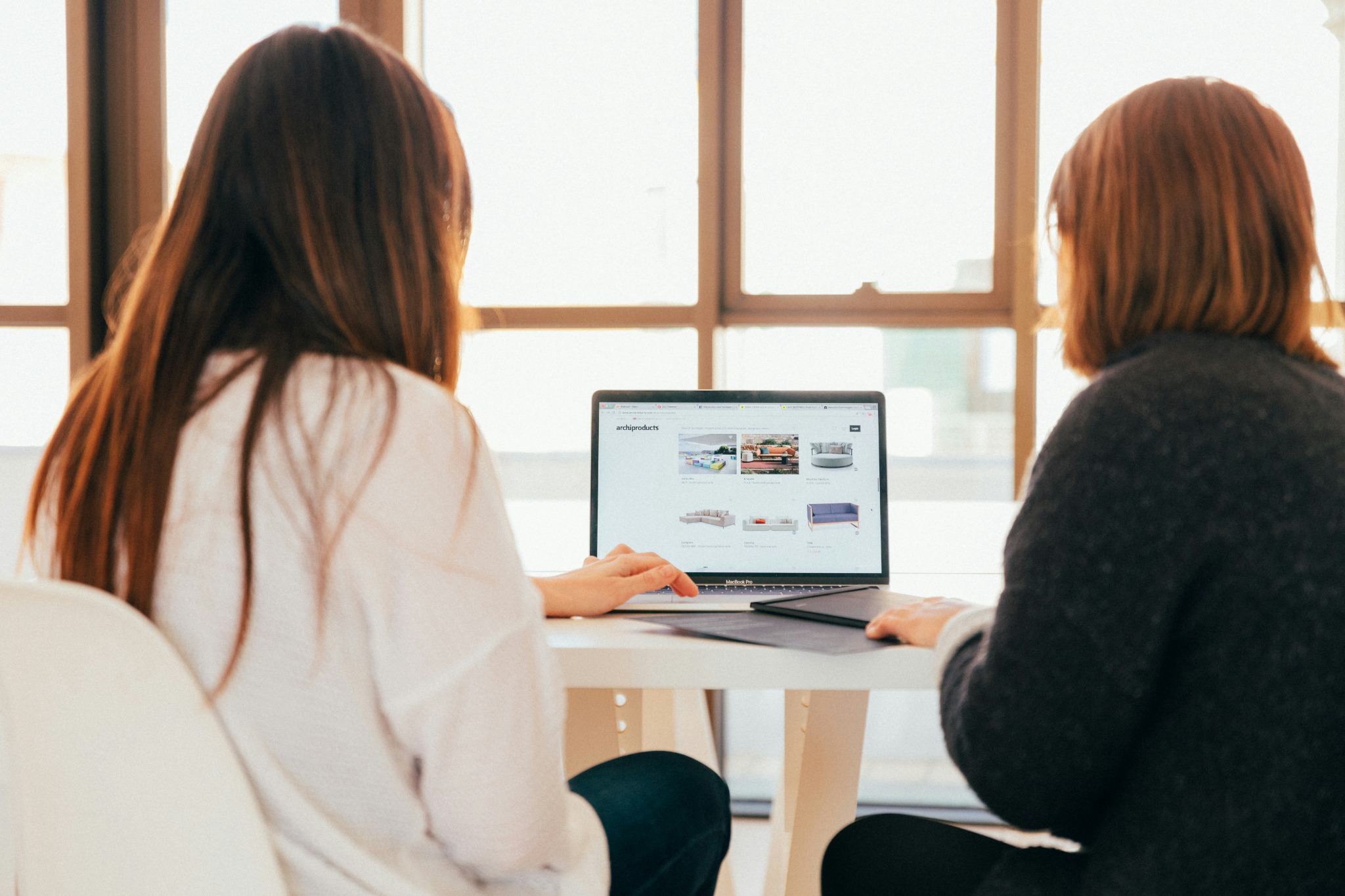 Two professionals reviewing a business website together on a laptop