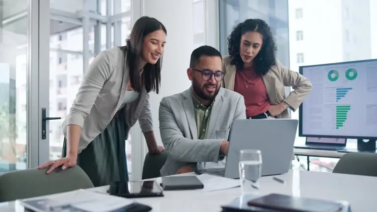 Colleagues reviewing information together at a laptop